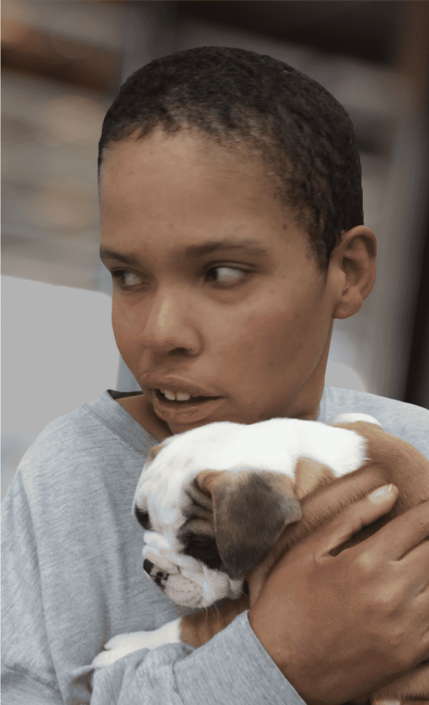 Young woman holding a bulldog puppy, close-up shot.